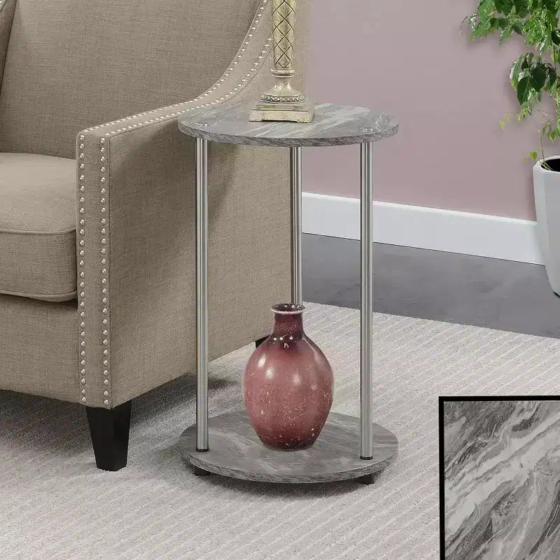 Table d'appoint ronde à deux niveaux HomeStock Belmont avec pieds en acier inoxydable, étagères robustes en panneaux de particules et style moderne contemporain.